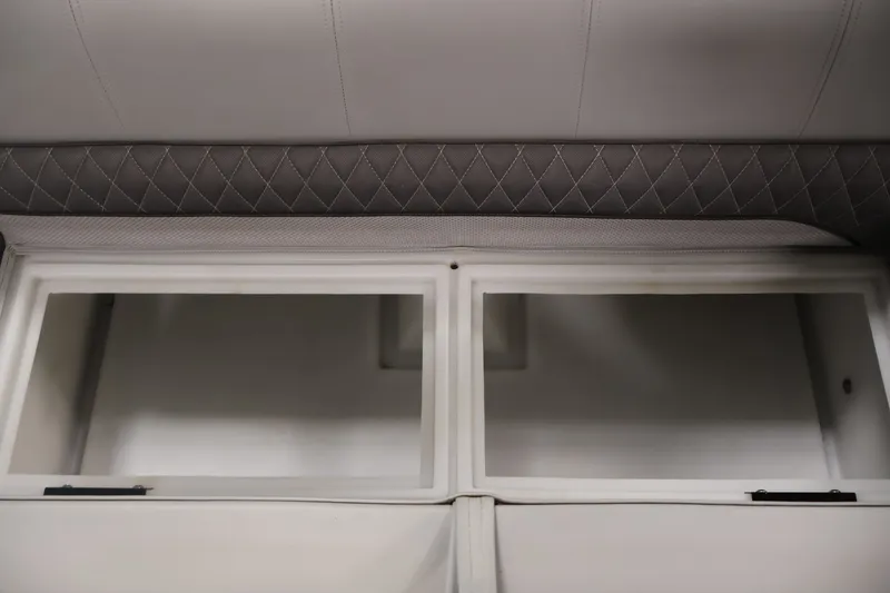 Slide: The Image of Interior storage compartments of 2025 Ranger Reata 220C boat with quilted upholstery. - 32