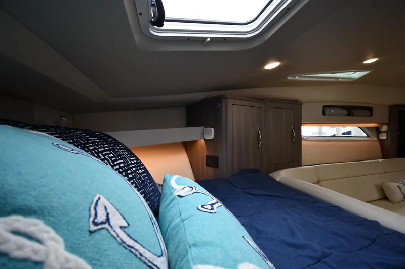 Slide: The Image of Interior cabin of 2021 Regal 35 Sport Coupe with nautical-themed bedding. - 30