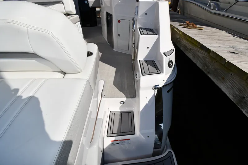 Slide: The Image of 2021 Regal 35 Sport Coupe boat interior with white seating and dockside view. - 23
