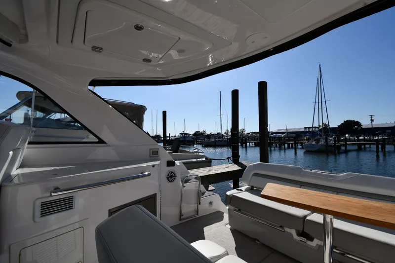 Slide: The Image of De afbeelding toont de cockpit van een Regal 35 Sport Coupe 2021 met uitzicht op een jachthaven. - 19