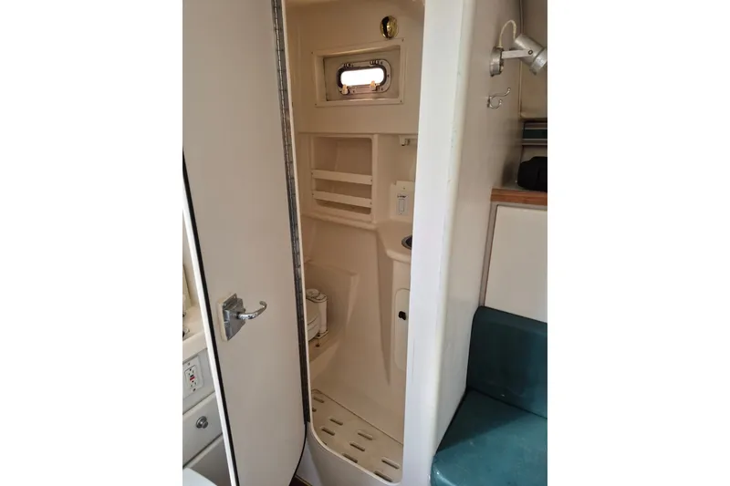 Slide: The Image of 1996 Pursuit 3000 Offshore boat interior with compact bathroom and seating area. - 40