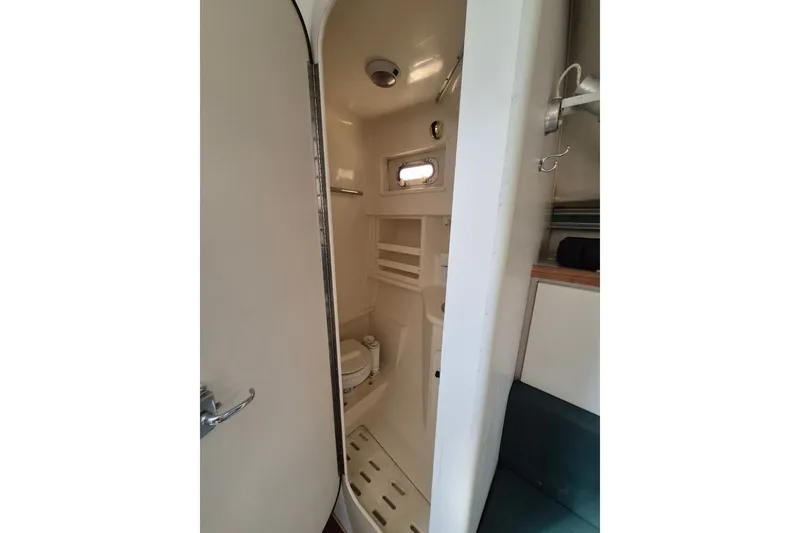 Slide: The Image of 1996 Pursuit 3000 Offshore boat bathroom interior with compact design and essential amenities. - 42