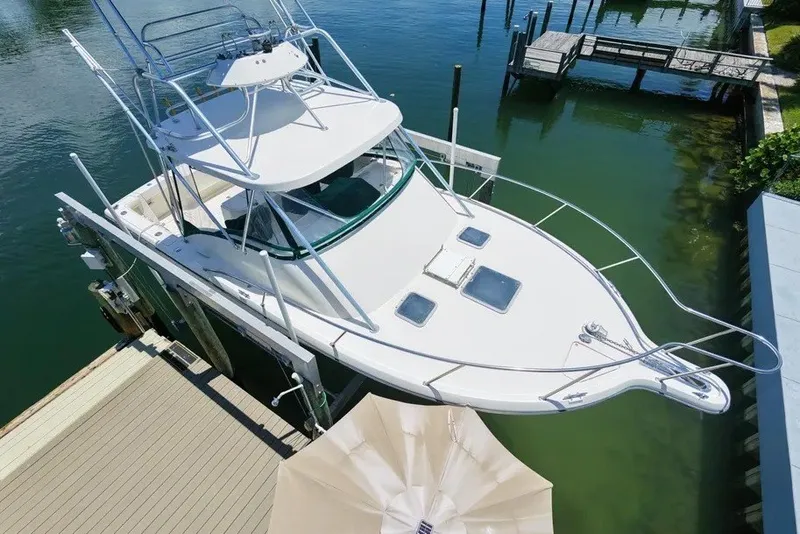The Image of 1996 Pursuit 3000 Offshore boat docked in calm marina waters. - 10