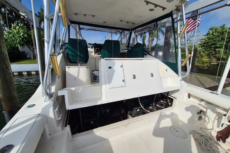 Slide: The Image of 1996 Pursuit 3000 Offshore boat interior with green seats and American flag. - 32