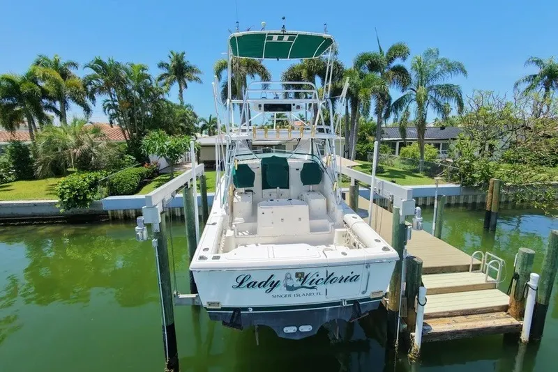Slide: The Image of 1996 Pursuit 3000 Offshore boat docked near palm trees, labeled "Lady Victoria." - 4