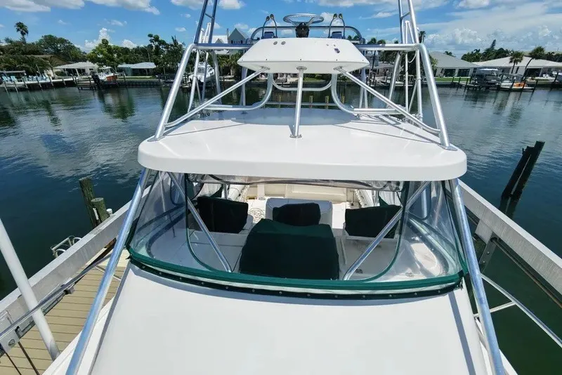 Slide: The Image of 1996 Pursuit 3000 Offshore boat docked at a marina under a clear blue sky. - 8
