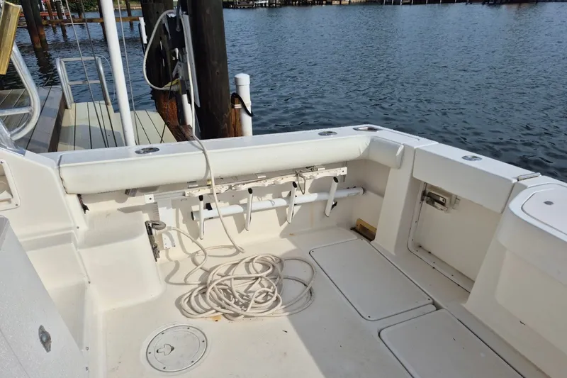 Slide: The Image of 1996 Pursuit 3000 Offshore boat deck with coiled rope, docked by the water. - 17