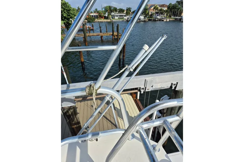 Slide: The Image of 1996 Pursuit 3000 Offshore boat docked by a scenic waterfront. - 61