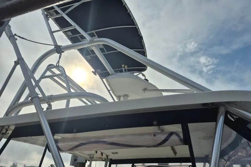 Slide: The Image of 1996 Pursuit 3000 Offshore boat with metal framework against a cloudy sky. - 12