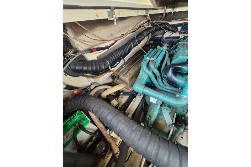 Slide: The Image of Engine compartment of a 1996 Pursuit 3000 Offshore boat, showcasing hoses and components. - 30