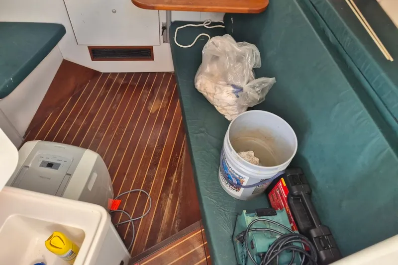 Slide: The Image of Interior of a 1996 Pursuit 3000 Offshore boat with tools and cleaning supplies. - 53