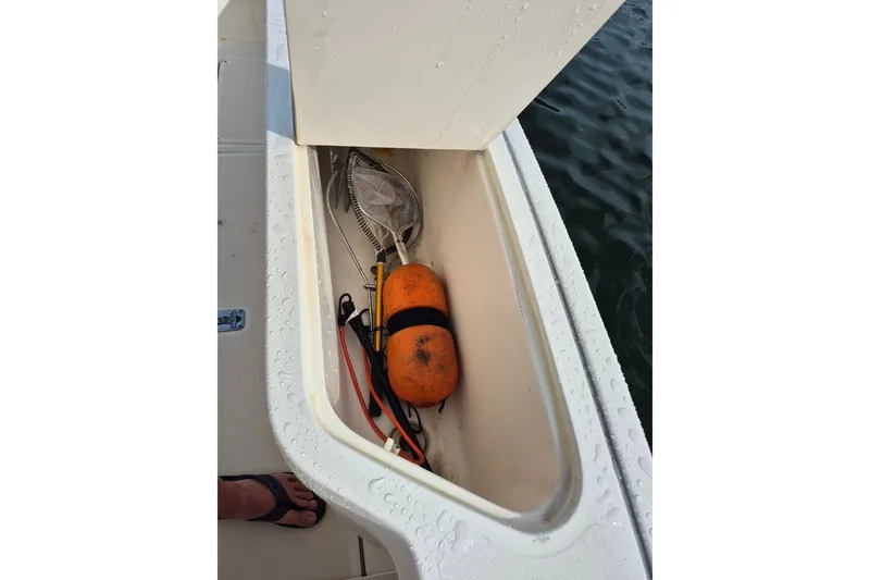 Slide: The Image of Storage compartment on a 1996 Pursuit 3000 Offshore boat with fishing gear and buoy. - 15