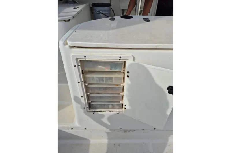 Slide: The Image of 1996 Pursuit 3000 Offshore boat storage compartment with tackle boxes. - 24