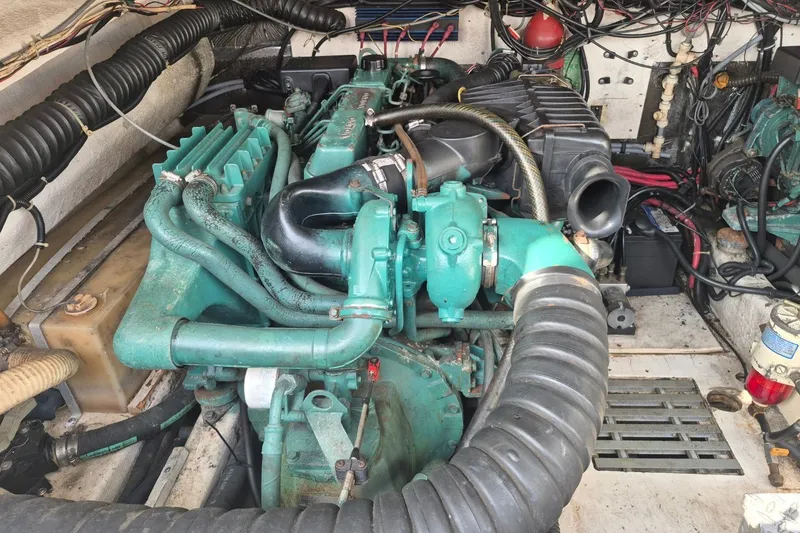 Slide: The Image of Engine compartment of a 1996 Pursuit 3000 Offshore boat, showcasing detailed mechanical components. - 25