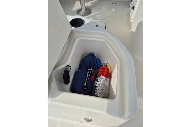 Slide: The Image of Storage compartment on a 1996 Pursuit 3000 Offshore boat with cleaning supplies. - 19