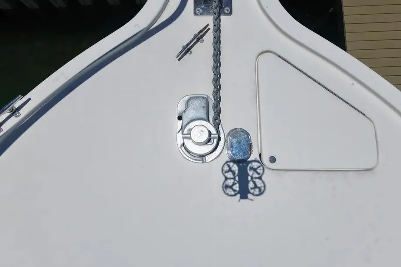 Slide: The Image of Bow deck of 1996 Pursuit 3000 Offshore with anchor chain and hatch. - 3