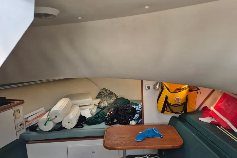 Slide: The Image of Interior of a 1996 Pursuit 3000 Offshore boat with stored equipment and seating area. - 52
