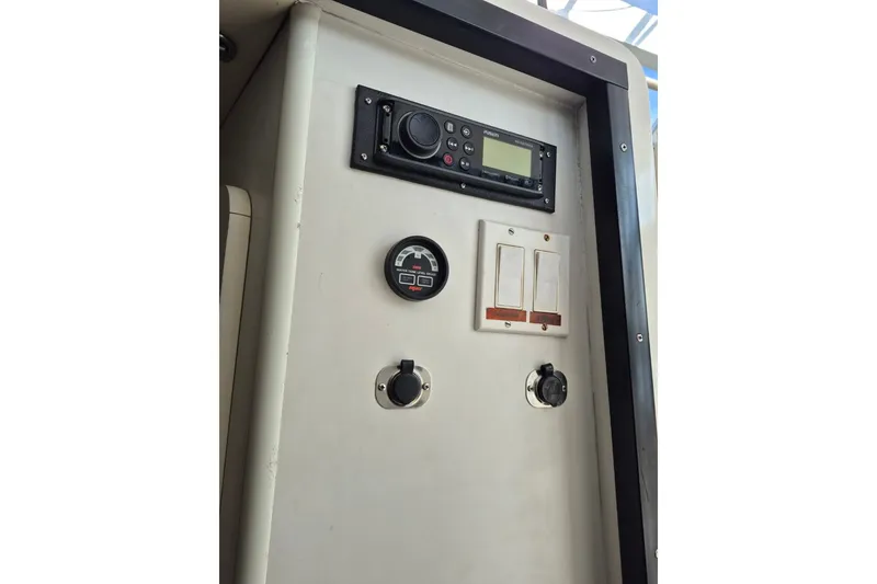 Slide: The Image of Control panel of a 1996 Pursuit 3000 Offshore boat, featuring gauges and switches. - 49