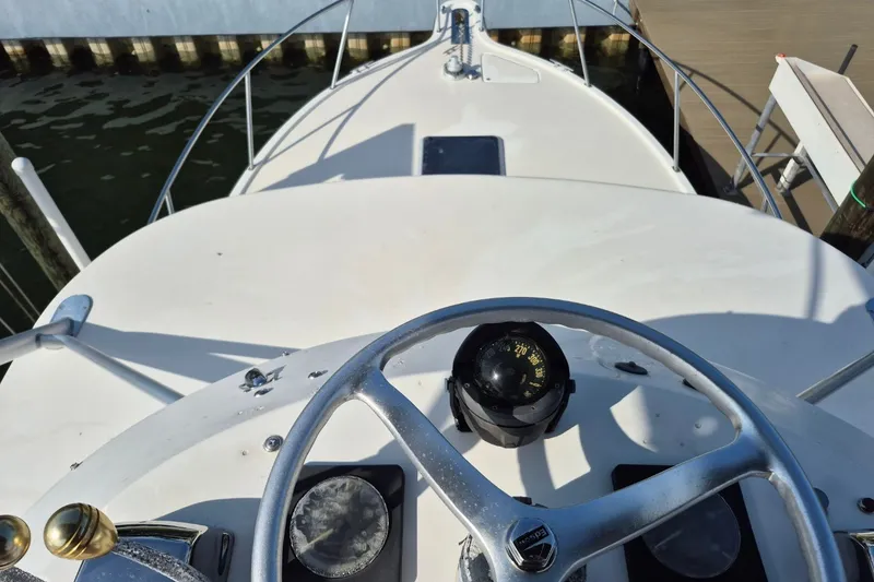 Slide: The Image of 1996 Pursuit 3000 Offshore boat helm with compass and steering wheel. - 60