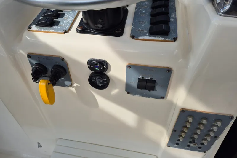 Slide: The Image of Control panel of a 1996 Pursuit 3000 Offshore boat with switches and dials. - 23