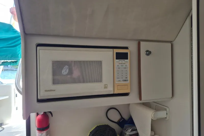 Slide: The Image of Built-in microwave on a 1996 Pursuit 3000 Offshore boat interior. - 48