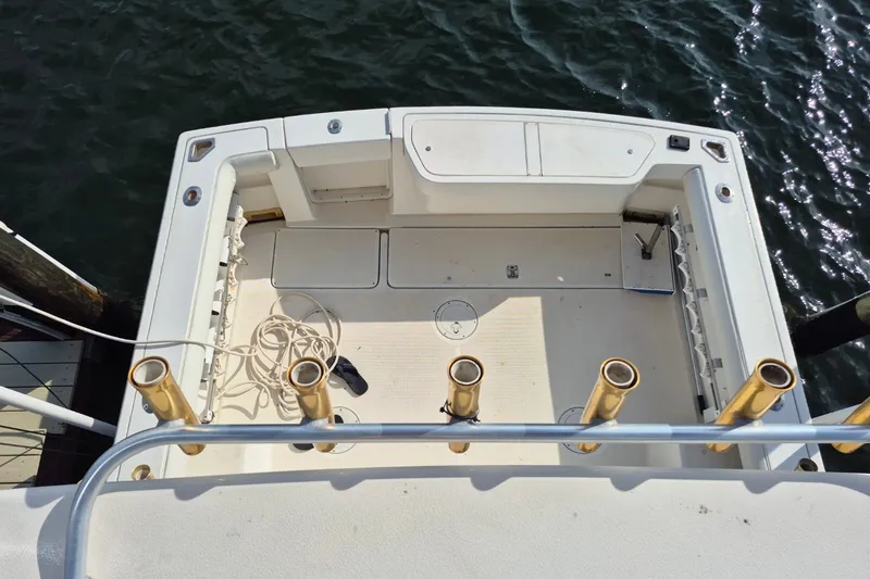 Slide: The Image of 1996 Pursuit 3000 Offshore boat deck with rod holders and storage compartments. - 63