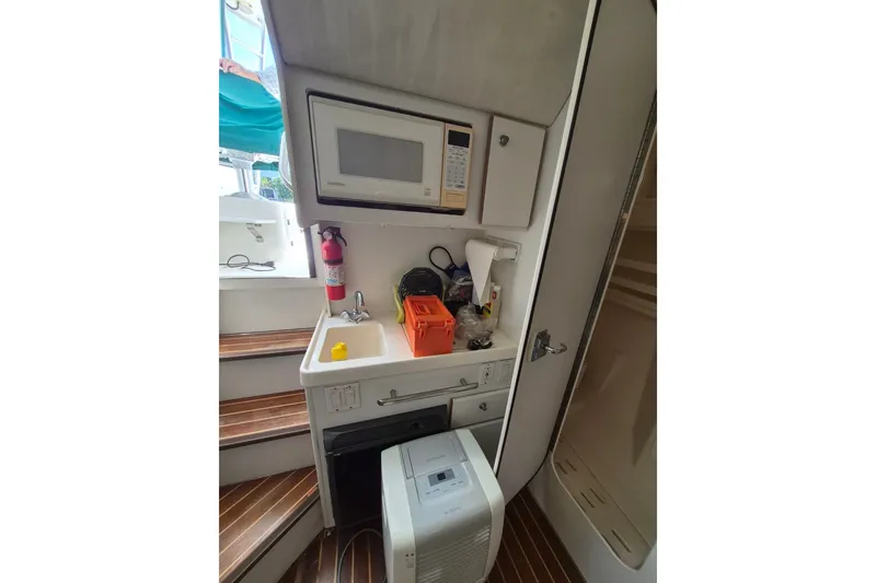 Slide: The Image of 1996 Pursuit 3000 Offshore boat interior with kitchenette, microwave, and sink. - 41