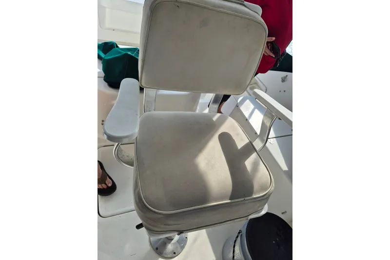 Slide: The Image of 1996 Pursuit 3000 Offshore boat seat with white upholstery and armrests. - 55