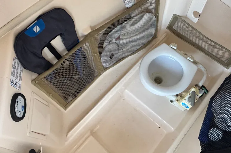 Slide: The Image of Interior of a 2008 Grady-White Freedom 275 boat, featuring a compact marine toilet. - 19