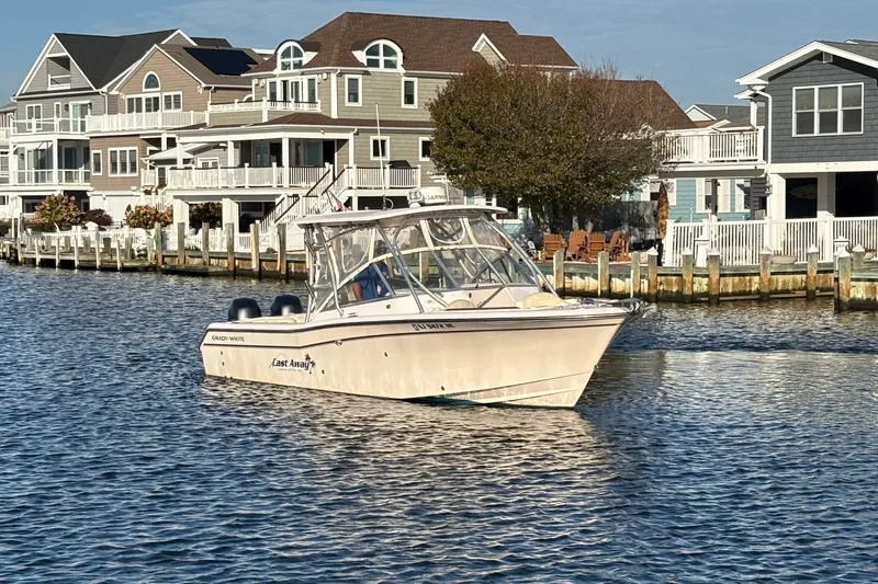 Slide: The Image of 2008 Grady-White Freedom 275 boat on water near waterfront homes. - 2