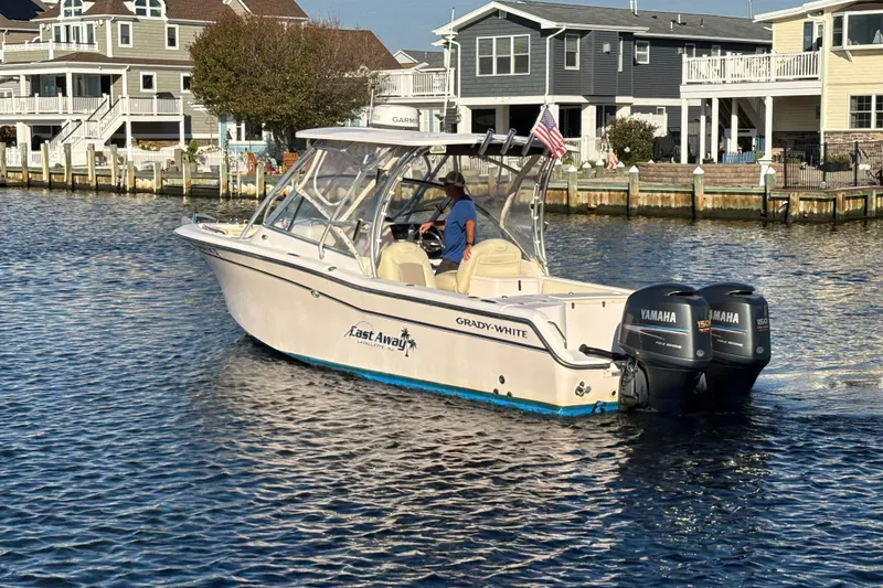 Slide: The Image of Grady-White Freedom 275 boat cruising near waterfront homes, featuring twin Yamaha engines. - 6