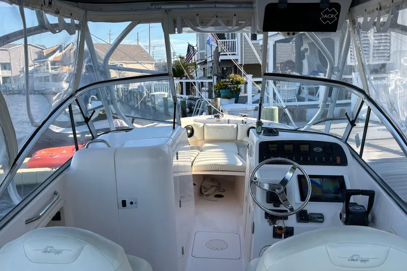 Slide: The Image of 2008 Grady-White Freedom 275 boat interior with helm, seating, and clear canopy. - 8