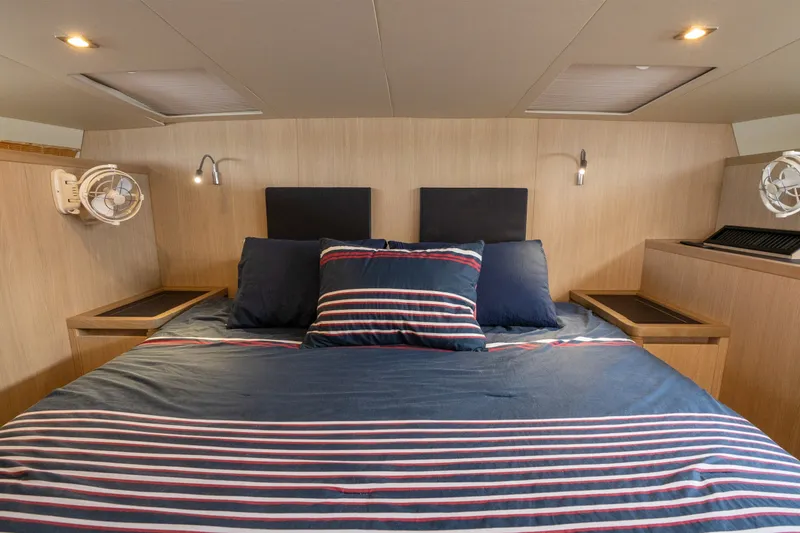 Slide: The Image of Luxurious bedroom interior of 2018 Aquila 44 Yacht with striped bedding and modern lighting. - 27