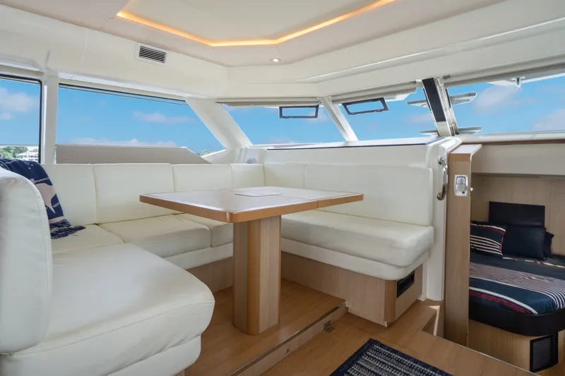 Slide: The Image of Luxurious interior of 2018 Aquila 44 Yacht with white seating and wooden table. - 24