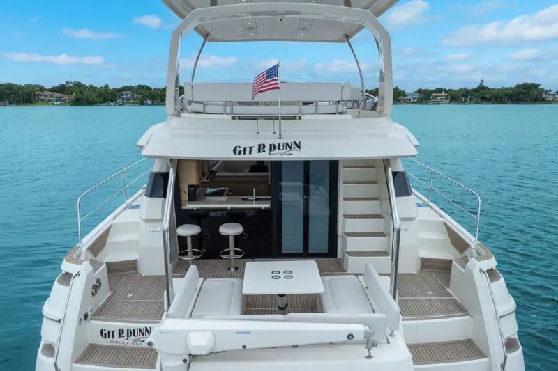 Slide: The Image of Aquila 44 Yacht 2018 on serene water, featuring spacious deck and American flag. - 16