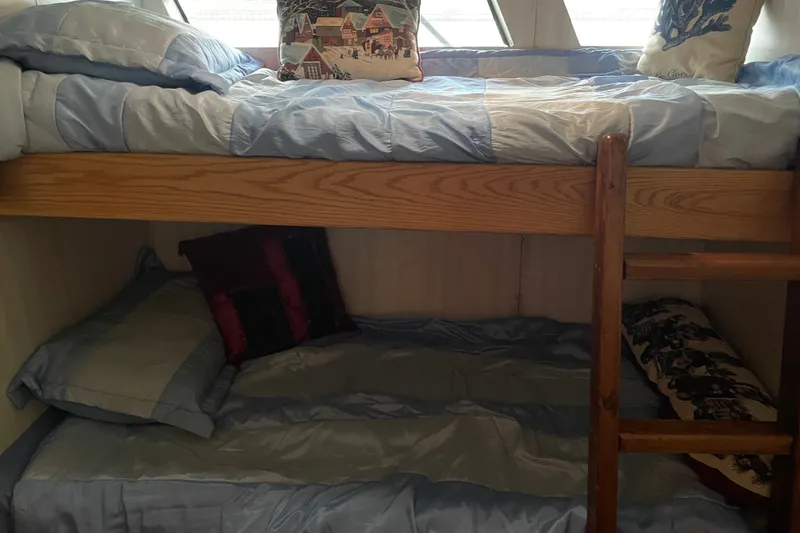 Slide: The Image of Bunk beds with blue bedding inside a 1996 WEIST 62 Convertible yacht cabin. - 18