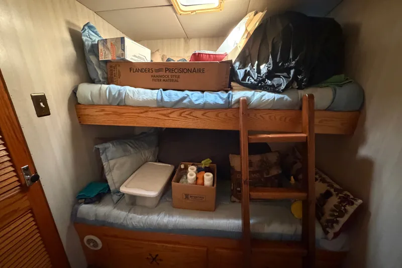 Slide: The Image of Bunk beds in a 1996 WEIST 62 Convertible, with storage boxes and a wooden ladder. - 17