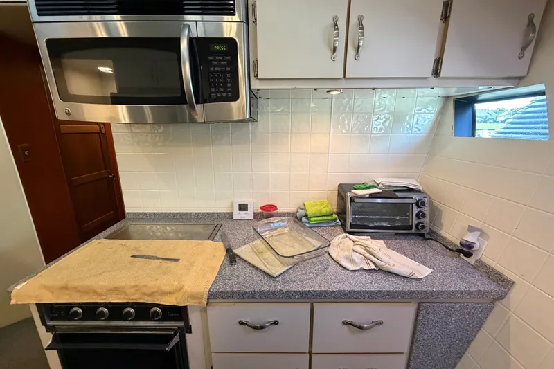 Slide: The Image of Compact kitchen in a 1996 WEIST 62 Convertible, featuring microwave, oven, and countertop appliances. - 15