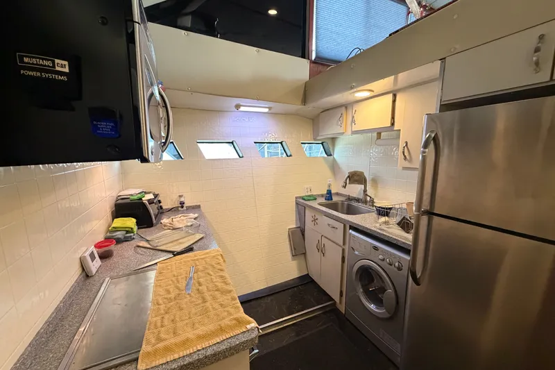 Slide: The Image of Compact kitchen in a 1996 WEIST 62 Convertible yacht with modern appliances. - 14