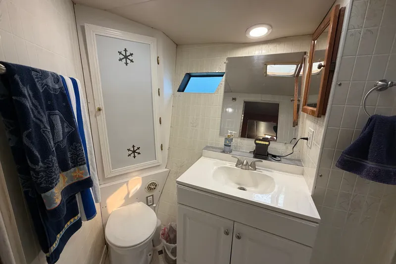 Slide: The Image of Bathroom interior of 1996 WEIST 62 Convertible yacht, featuring sink, mirror, and nautical decor. - 19