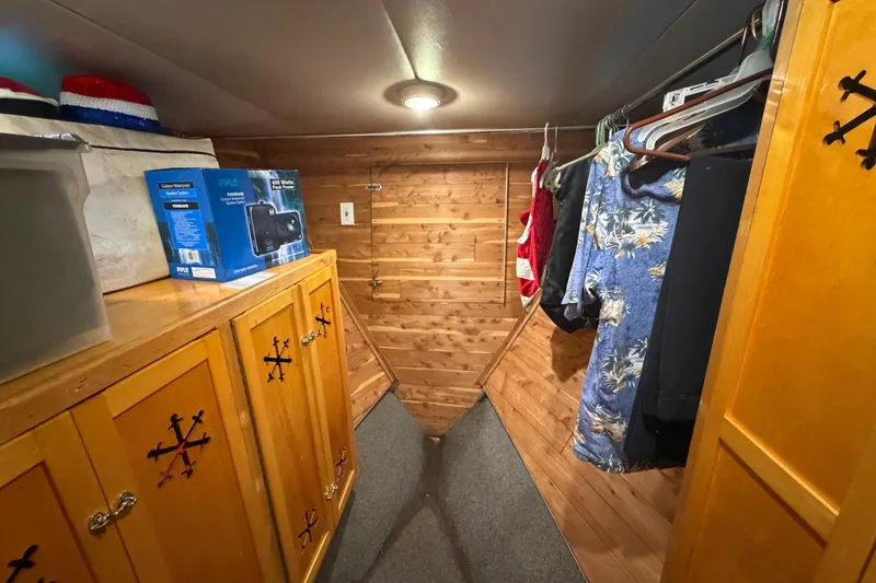Slide: The Image of Cozy wooden closet in 1996 WEIST 62 Convertible, featuring clothes and storage cabinets. - 25