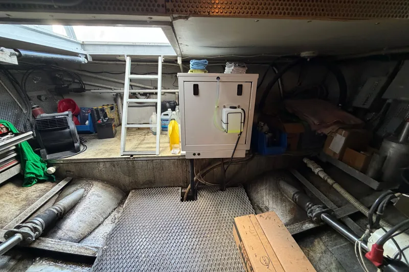 Slide: The Image of Engine room of a 1996 WEIST 62 Convertible boat, featuring equipment and storage. - 39