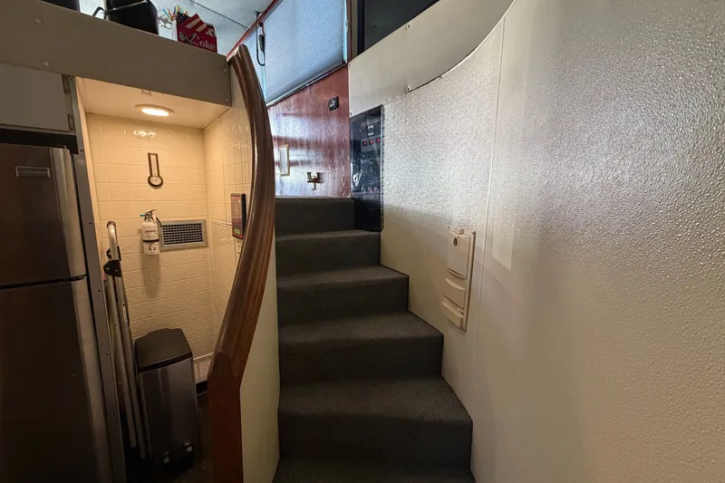 Slide: The Image of Interior of a 1996 WEIST 62 Convertible yacht with stairs and kitchenette area. - 13