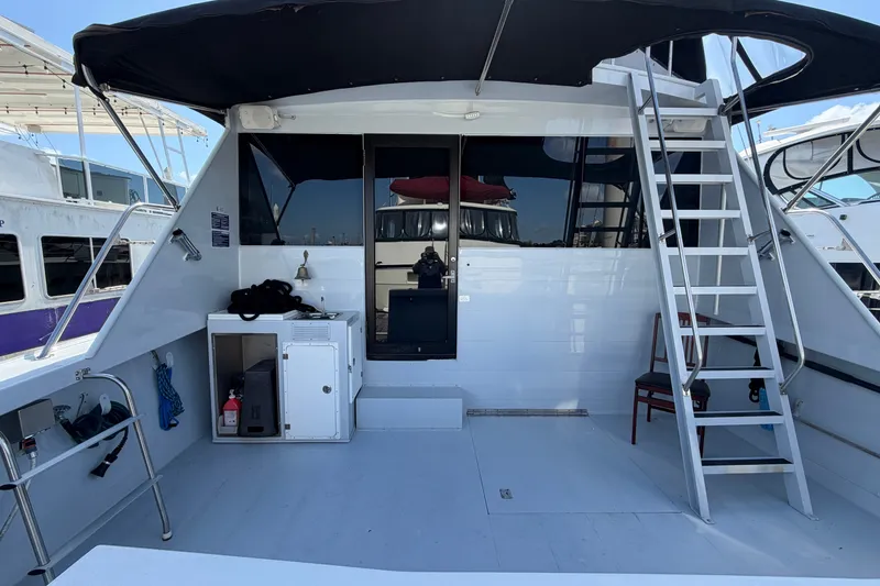 Slide: The Image of 1996 WEIST 62 Convertible yacht deck with ladder, storage, and seating under canopy. - 50