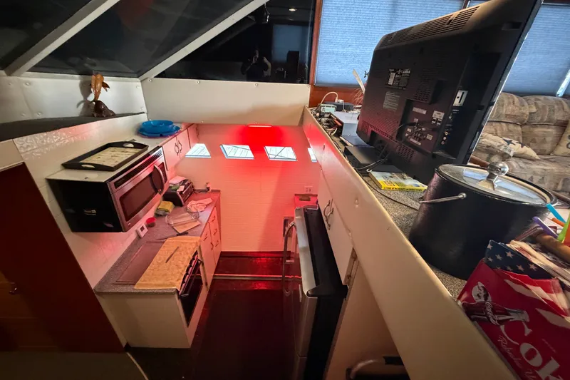 Slide: The Image of Interior of a 1996 WEIST 62 Convertible yacht kitchen with appliances and TV. - 30