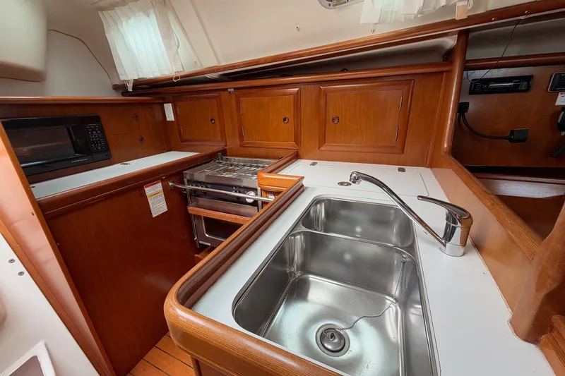 Slide: The Image of 2001 Beneteau Oceanis 331 yacht kitchen with sink, stove, and microwave. - 15