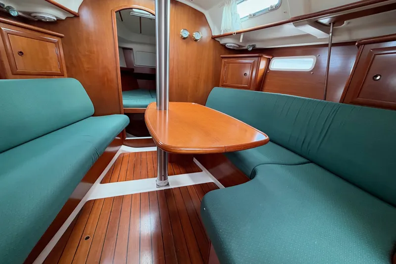 Slide: The Image of Interior of 2001 Beneteau Oceanis 331 sailboat with green seating and wooden table. - 13