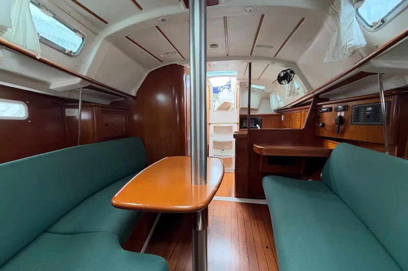 Slide: The Image of Interior of 2001 Beneteau Oceanis 331 sailboat with wood finish and green seating. - 4