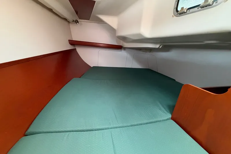 Slide: The Image of Interior cabin of 2001 Beneteau Oceanis 331 sailboat with green cushions and wooden accents. - 21