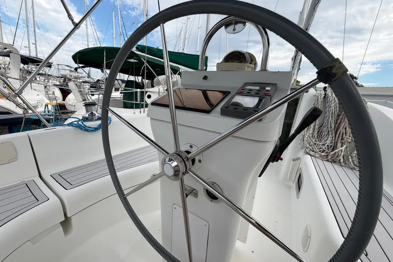 Slide: The Image of Steering wheel of a 2001 Beneteau Oceanis 331 sailboat in a marina setting. - 9
